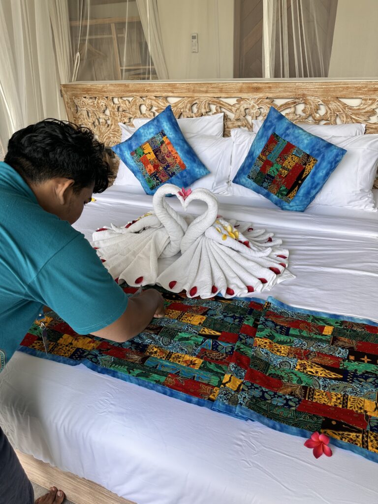 Housekeeping staff preparing a romantic bed setup at Kizmet Fit Retreat